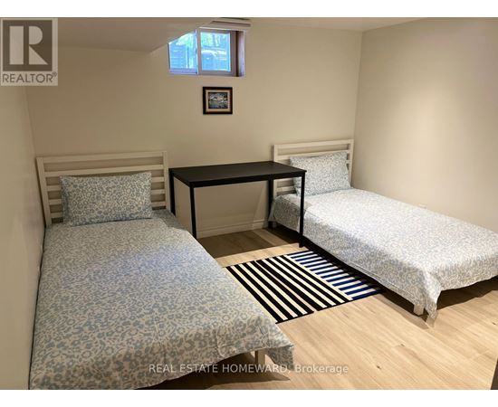A bedroom with two beds and a desk.