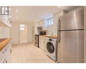 A modern kitchen with a stainless steel refrigerator and wooden countertops.