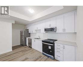A kitchen with white cabinets and a black oven.