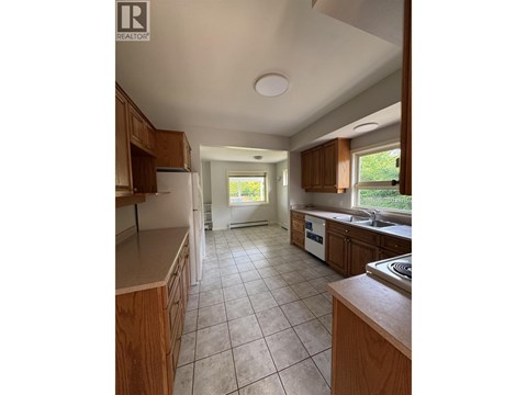 A kitchen with wooden cabinets and a tiled floor.