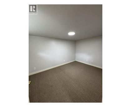 A room with a carpeted floor and white walls.