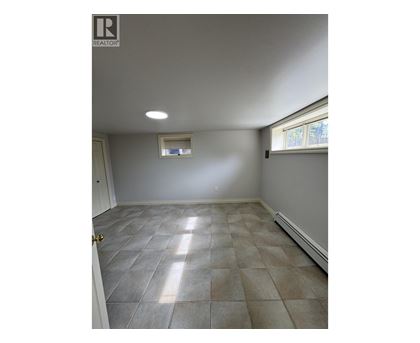 A room with tile flooring and a window.