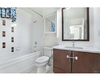 A white toilet sits in a bathroom next to a bathtub.