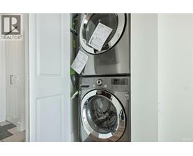 A washing machine with a white door and a black and white checkered floor.