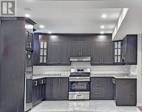 A modern kitchen with dark wood cabinets and stainless steel appliances.