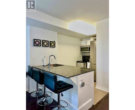 A kitchen with a black counter top and white cabinets.