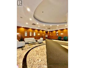 A spacious lobby with a marble floor and wooden panelled walls.