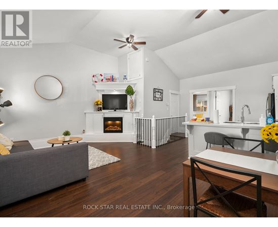 A living room with a grey couch and a fireplace.