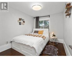 A bedroom with a white bed and a grey rug.