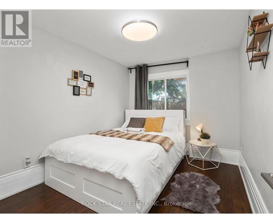 A bedroom with a white bed and a grey rug.
