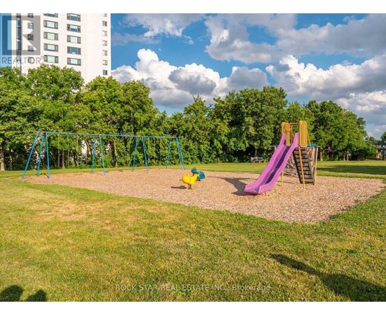 A playground with a green swing set and a purple slide.
