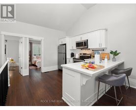 A kitchen with white cabinets and a wooden floor.