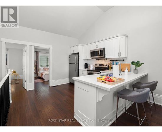 A kitchen with white cabinets and a wooden floor.