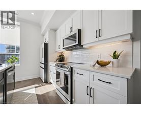 A modern kitchen with white cabinets and a black stove top.