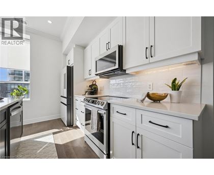 A modern kitchen with white cabinets and a black stove top.
