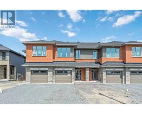 A modern two-story house with a brick facade and multiple garage doors.