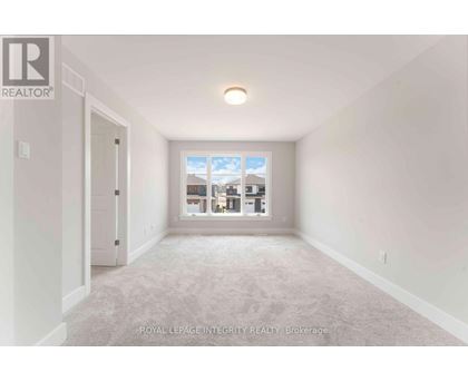 A white room with a window showing a view of other buildings.