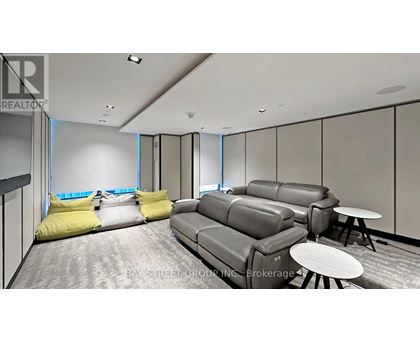 A living room with grey couches and yellow pillows.