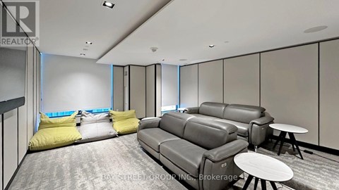 A living room with grey couches and yellow pillows.