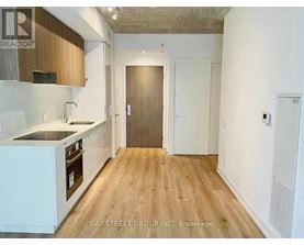 A kitchen with wooden floors and white cabinets.