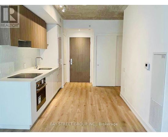A kitchen with wooden floors and white cabinets.