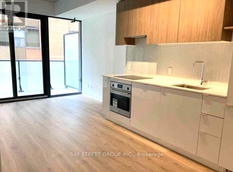 A modern kitchen with a stove top oven and a sink.