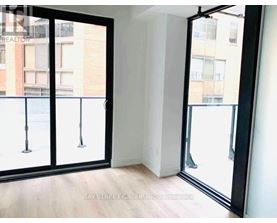 A room with a view of a street through a glass door.