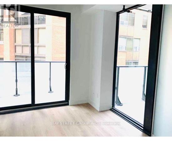 A room with a view of a street through a glass door.