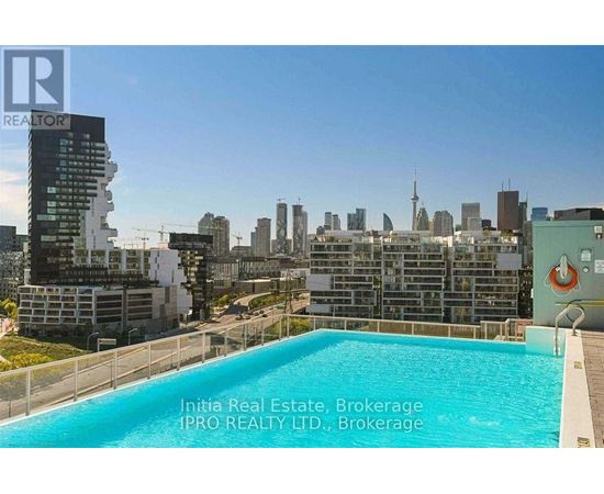 A pool on a balcony with a city skyline in the background.