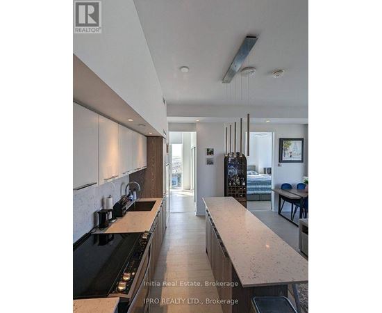 A kitchen with a black stove top oven and white cabinets.
