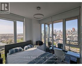 A bedroom with a large bed and a view of the city.