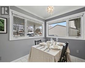 A dining room with a table set for two and a view of the backyard.