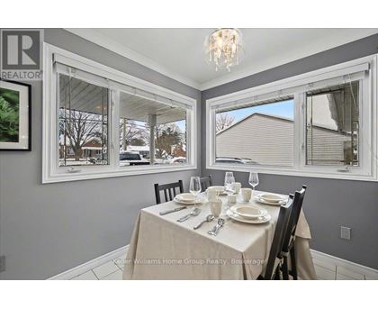 A dining room with a table set for two and a view of the backyard.