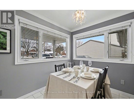 A dining room with a table set for two and a view of the backyard.
