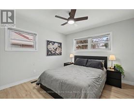 A bedroom with a bed, nightstand, and a ceiling fan.