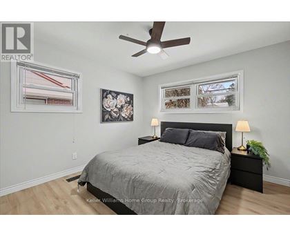 A bedroom with a bed, nightstand, and a ceiling fan.