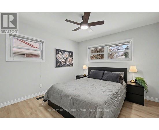 A bedroom with a bed, nightstand, and a ceiling fan.