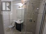 A bathroom with a toilet, a sink and a shower.