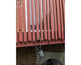 A red fence with a padlock hanging from it.