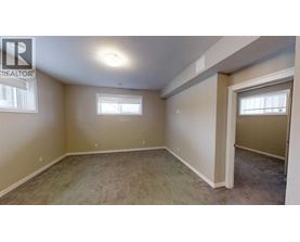 A room with a carpeted floor and a window.