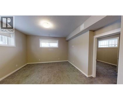 A room with a carpeted floor and a window.