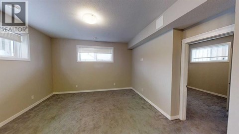 A room with a carpeted floor and a window.