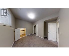 A realtor sign is on the wall of a sparsely furnished room.