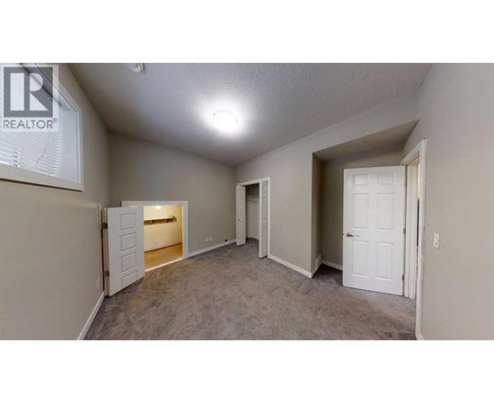 A realtor sign is on the wall of a sparsely furnished room.