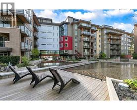 A row of modern apartment buildings with a wooden deck in front.