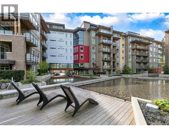 A row of modern apartment buildings with a wooden deck in front.
