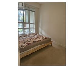 A bedroom with a bed and a window.