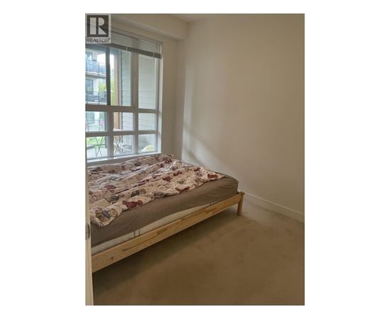 A bedroom with a bed and a window.