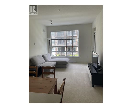 A living room with a grey couch and a wooden coffee table.