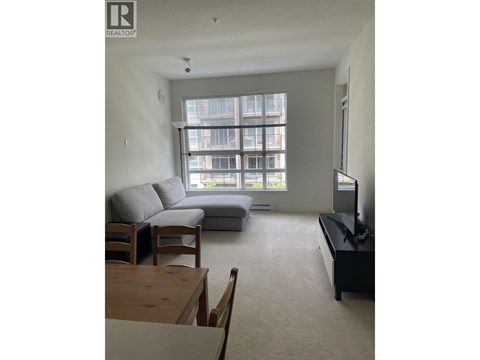 A living room with a grey couch and a wooden coffee table.